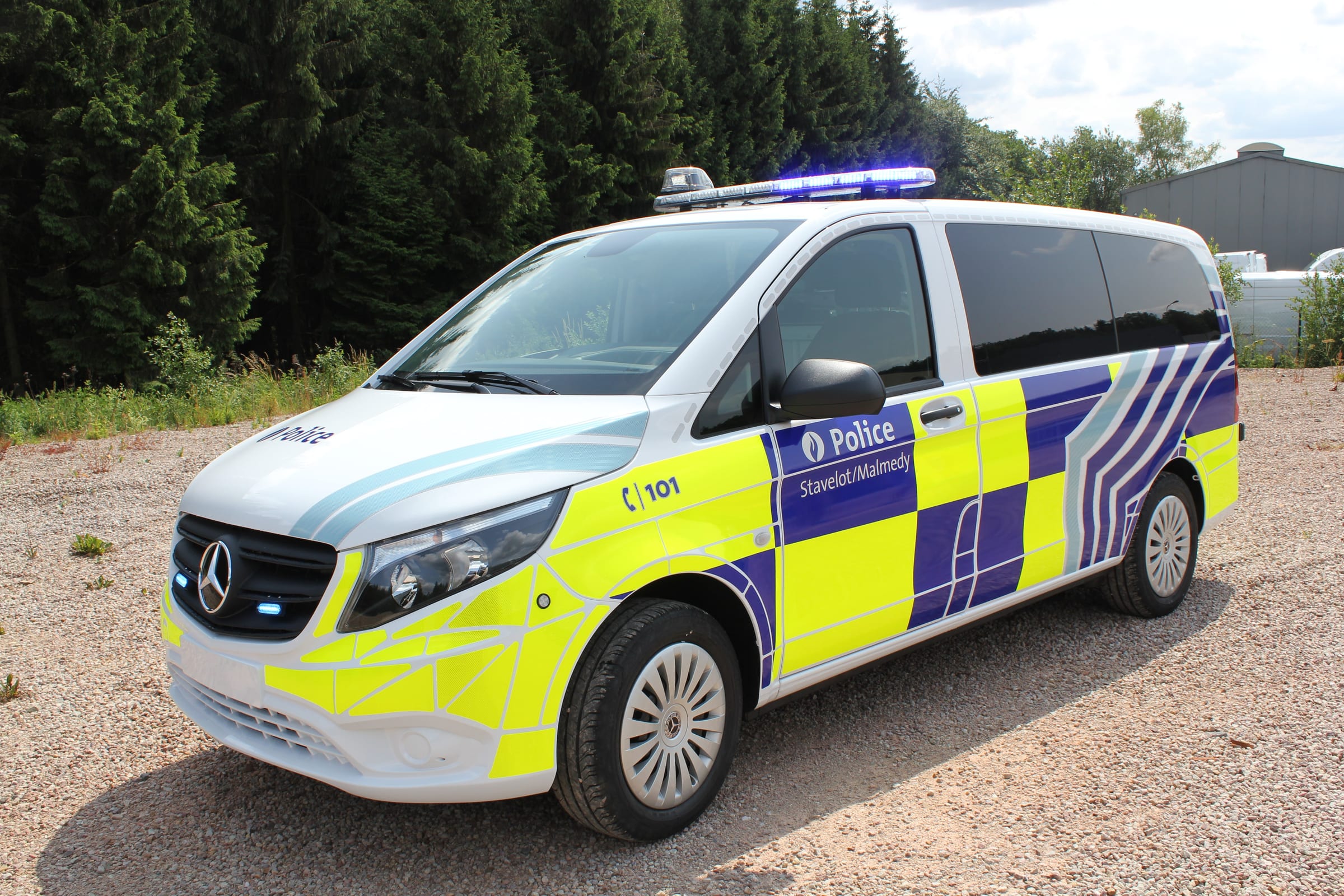 Mercedes Vito de police vu de trois quarts avant, gyrophares bleus de calandre et rampe de toit allumés