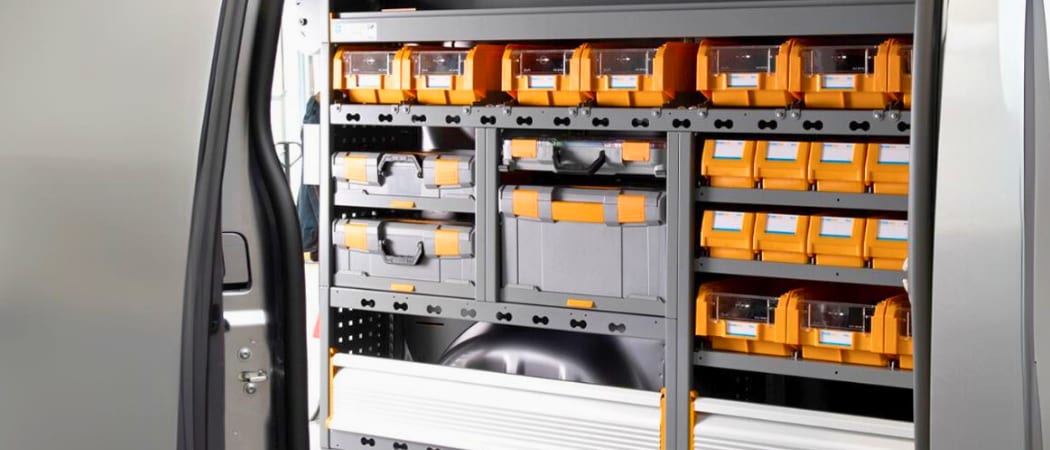 Rayonnage monté dans un fourgon : bacs à bec orange, coffrets de rangement et étagères à hauteur réglable