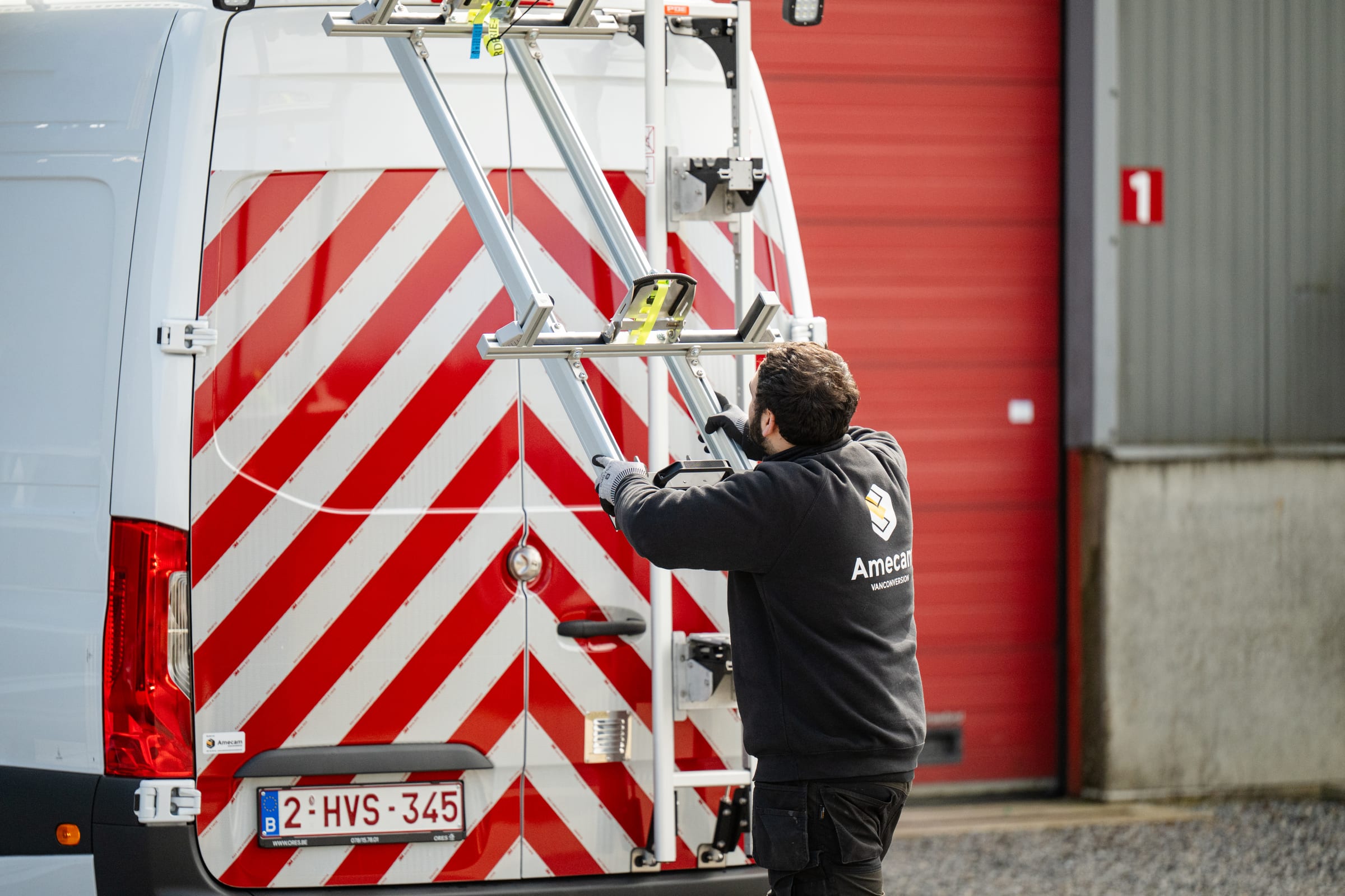 Technicien Amecam installant une galerie de toit sur un fourgon à chevrons de signalisation